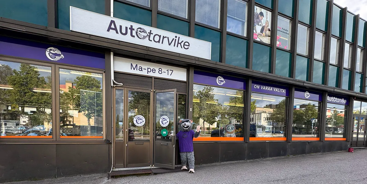Autotarvike Kajaanin-liikkeen julkisivu ja sisäänkäynnin ovella vastassa RAT-maskotti.