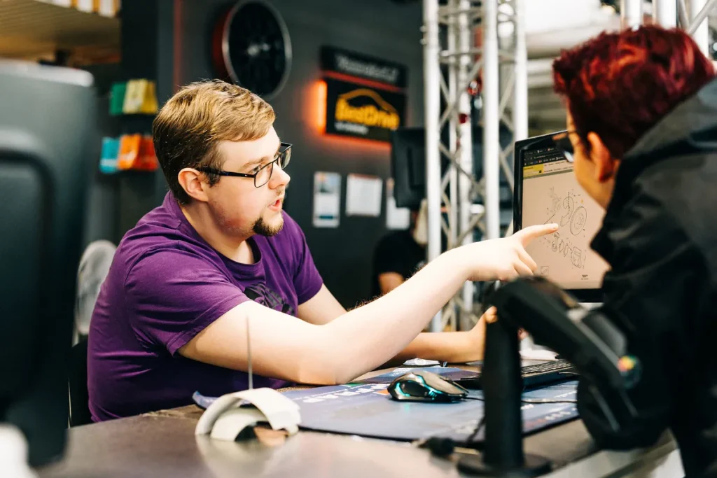 Autotarvikkeen asiantuntija etsimässä oikeaa varaosaa asiakkaalle palvelutiskillä.