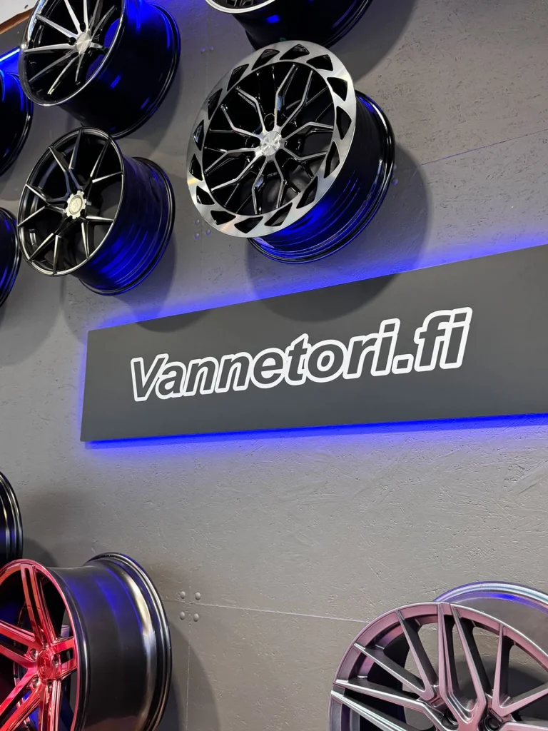 Valaistu Vannetori-logo ja eri tyylisiä vanteita koristeena seinällä.